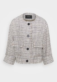 Cropped tweed jacket in beige and blue with a textured pattern, frayed edges, and three black buttons on the front.