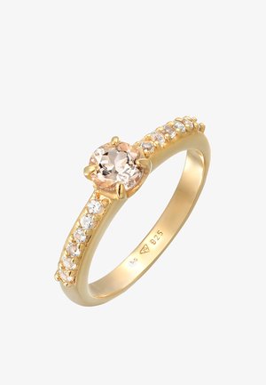 Złoty pierścionek z okrągłym, jasnoróżowym kamieniem centralnym i małymi przezroczystymi kamieniami wzdłuż obrączki. Oznaczony znakiem "925", co wskazuje na srebro sterlingowe.