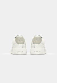 White sneakers with a smooth leather upper, rounded shape, contrast heel accents, and ARKK branding on the back of the sole.