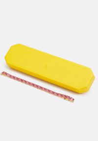 Yellow octagonal jewelry case beside a pink gem bracelet with gold settings, showcasing rectangular stones linked in a repeating pattern.