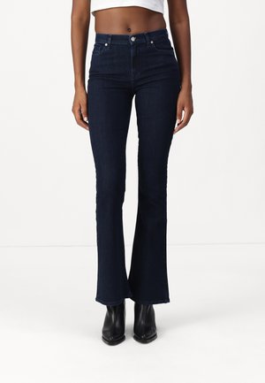Mørkeblå, vide jeans med høy midje og fem lommer, laget av denim. Har knappelukking og stikninger.