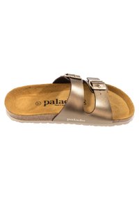 Bruine leren slipper met twee verstelbare gespstrappen, een zachte suede voetbed en een rubberen zool. Merkennaam "Palado" zichtbaar.