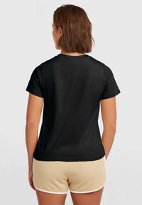 Black short-sleeve t-shirt featuring a round neckline and smooth, soft texture, paired with beige shorts with a textured pattern and white trim.