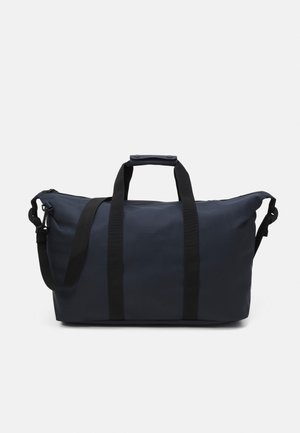 Marine duffelbag i vannavstøtende stoff, med to svarte håndtak, justerbar skulderstropp og dobbel glidelås.
