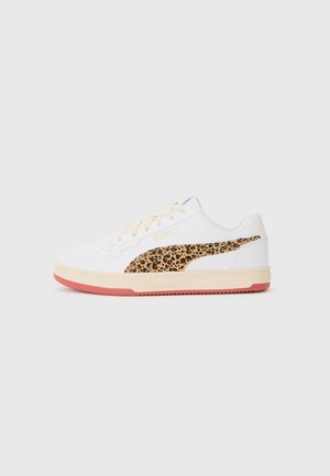 Basket blanche avec des lacets beiges, dotée d'une bande latérale à imprimé léopard. Tige en cuir blanc texturé et semelle en caoutchouc rose.