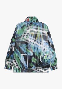 Multifarvet letvægtsjakke med et virvlet mønster i grøn, blå og sort med hvide geometriske detaljer og elastiske manchetter.