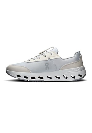 Hellgrauer und beiger Sportschuh mit weißer Sohle, schwarzer ovaler Aussparung und Schnürverschluss.