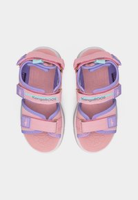 Παιδικά ροζ και μωβ πέδιλα KangaROOS με ρυθμιζόμενες λουριά με Velcro και λευκές σόλες, εμφανιζόμενα από πάνω προς τα κάτω.