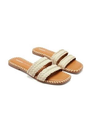 Sandalias deslizantes tejidas con tres tiras de color blanco roto y una plantilla color marrón claro, con suela plana y costuras decorativas a lo largo de los bordes.