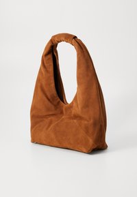 Brown suede bag with a unique, knot-style handle, featuring a large, open top and a soft, textured finish.