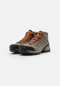 Wysokie buty trekkingowe w odcieniach szaro-czarnych z pomarańczowymi sznurówkami. Posiadają teksturowaną cholewkę, gumowy wzmocniony czubek oraz solidną podeszwę zapewniającą dobrą przyczepność.