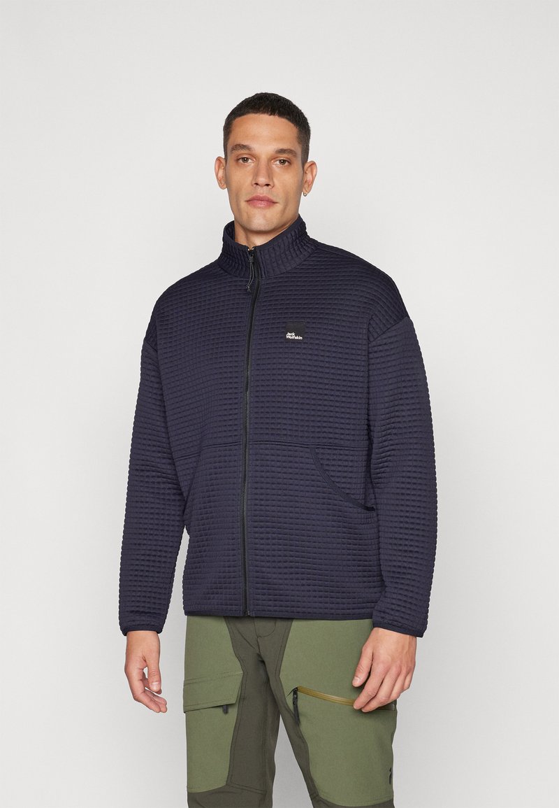 Giacca imbottita blu navy con zip e colletto alto, due tasche laterali e un piccolo logo sul petto, realizzata in tessuto testurizzato.
