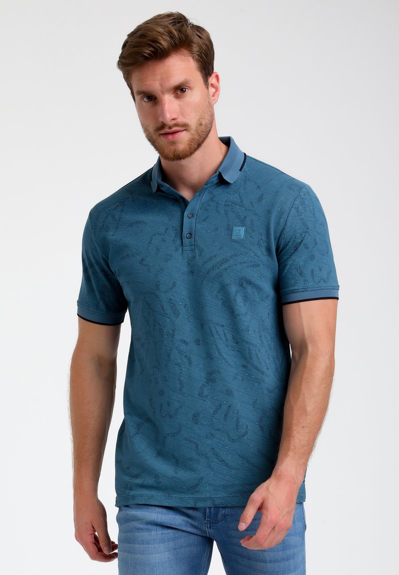 Polo shirt teal avec un motif texturé, patte de boutonnage, col contrastant et accents de manches, fabriqué à partir d'un tissu doux, design ajusté.