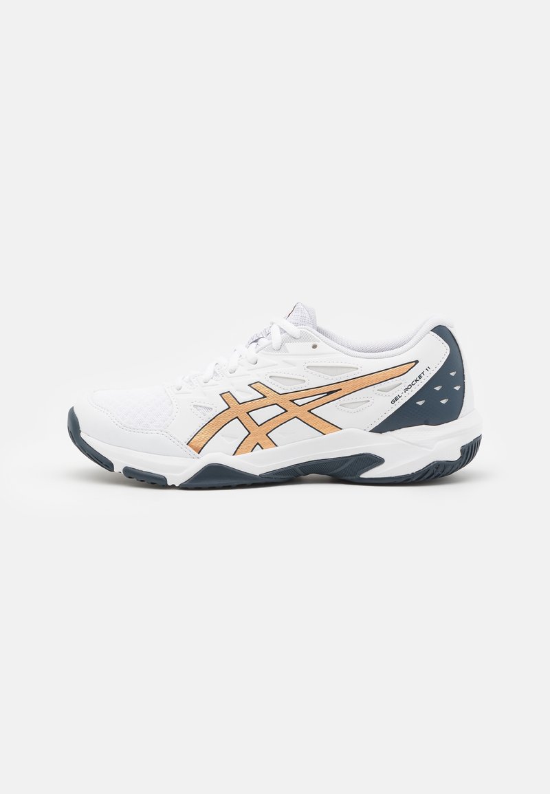 Chaussure de sport blanche avec des bandes de logo dorées et une semelle et un talon bleu foncé, étiquetée Gel-Rocket 11 sur le côté.