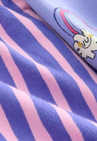 Tessuto a righe con strisce alternate di un viola chiaro e rosa, con una texture liscia e una grafica in stile cartone animato di un animale nell'angolo.