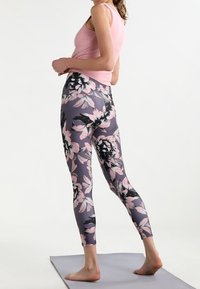 Leggings ajustados en gris con un patrón floral en rosa y negro. La cinturilla es alta, y la tela parece elástica y suave.
