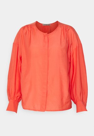 Bluză oversized coral, realizată dintr-un material ușor, cu guler rotund, mâneci lungi tip balon și o închidere cu nasturi anterior.