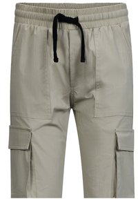 Lichtbeige cargobroek met een elastische tailleband, zwarte trekkoord en zijzakken. Gemaakt van een soepele, lichte stof.