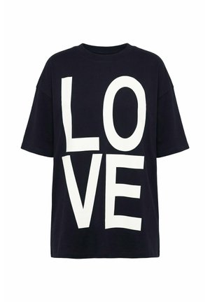 Camiseta negra de gran tamaño con grandes letras blancas que forman la palabra "LOVE" en el frente, dispuestas verticalmente en dos filas.