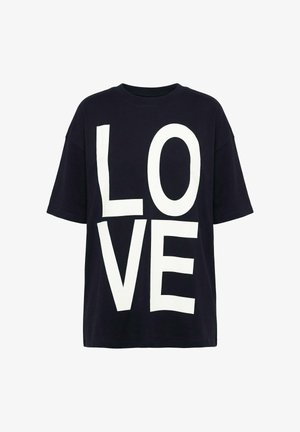 Camiseta negra de gran tamaño con grandes letras blancas que forman la palabra "LOVE" en el frente, dispuestas verticalmente en dos filas.