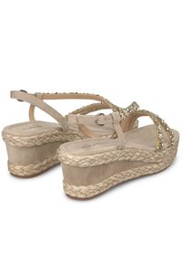 Beige wedge sandalen van suede materiaal, gevlochten jute tussenzool en decoratieve strass-accenten op de banden. Verstelbare gesp op de enkelband.
