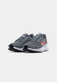 Gray mesh running shoes with a white sole and black traction. Features a red Nike swoosh, laces, and a padded collar for comfort.