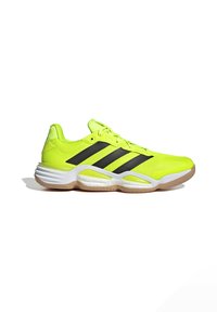 Zapatillas deportivas de color amarillo neón con rayas negras, parte superior de malla, suela acolchada y suela de goma que están diseñadas para el rendimiento y el soporte.