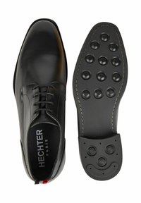 Schwarzer Lederschuh mit glatter Oberfläche, Schnürdesign, runder Zehenpartie und Gummisohle mit kreisförmigen Profilen. Markenlogo auf der Innensohle.