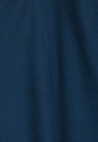 Donkerblauw, textiel met een strakke, geweven patroon, met een lichte val en glans. Heeft een consistente kleur over het hele oppervlak.