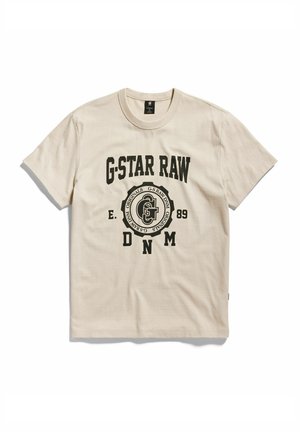 Beige Baumwoll-T-Shirt mit kurzen Ärmeln, das ein großes schwarzes "G-Star RAW"-Logo und ein kreisförmiges Grafikdesign auf der Vorderseite zeigt.