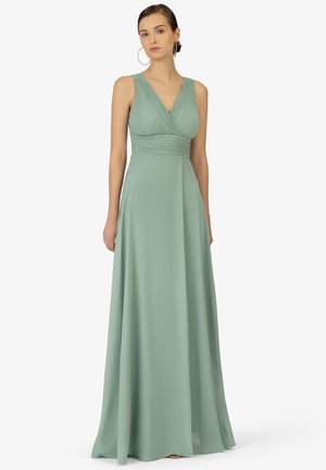 Robe fluide à longueur de sol en tissu vert doux. Présente un décolleté en V, un corsage plissé et un design sans manches avec un tombé élégant.