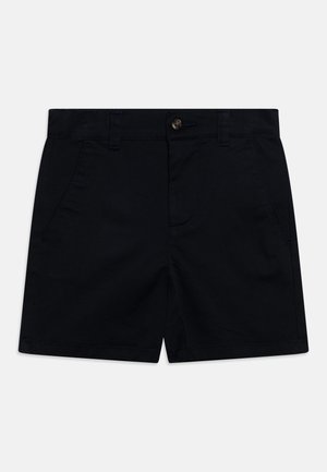 Shorts en coton noir sur mesure avec poches avant, passants de ceinture et fermeture à bouton à la taille sur un fond clair.