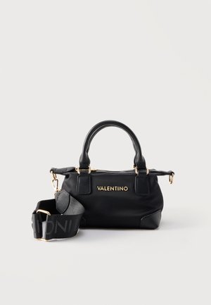 Μαύρη τσάντα Valentino με χρυσά μεταλλικά στοιχεία, διπλές λαβές και αφαιρούμενο, φαρδύ ιμάντα ώμου με λεπτομέρεια λογότυπου σε λευκό φόντο.