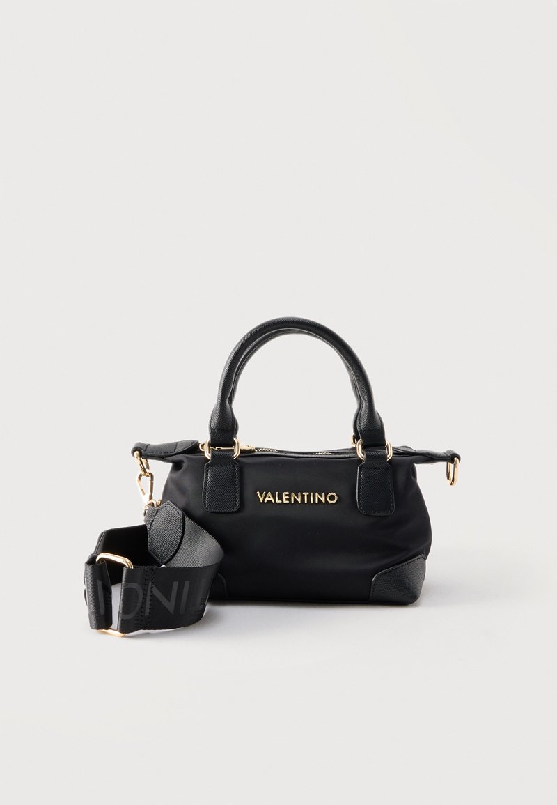 Μαύρη τσάντα Valentino με χρυσά μεταλλικά στοιχεία, διπλές λαβές και αφαιρούμενο, φαρδύ ιμάντα ώμου με λεπτομέρεια λογότυπου σε λευκό φόντο.