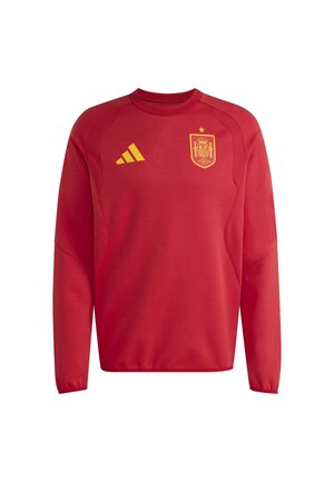 Κόκκινη μακριά αμάνικη αθλητική εμφάνιση με κίτρινο λογότυπο Adidas στα αριστερά και σήμα της εθνικής ομάδας ποδοσφαίρου της Ισπανίας στο δεξί στήθος.