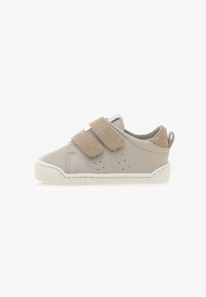 Sneaker per bambini in pelle grigia con strap in suede beige a Velcro, suola in gomma bianca, dettagli perforati e una linguetta sul tallone.