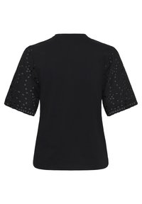 Haut noir à manches courtes avec dos uni et manches bouffantes transparentes brodées de motifs circulaires et bords festonnés.