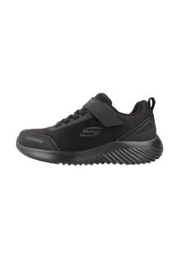 Zapatillas deportivas negras con parte superior de malla, un collar acolchado, correa ajustable y suela texturizada para agarre. Etiqueta de impermeabilidad visible en el lado.