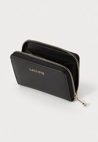 Cartera de cuero negro con cremallera dorada, que presenta un logotipo de la marca en la parte frontal, dos compartimentos y una textura suave.