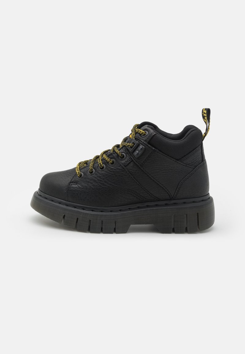 Bottine en cuir noir à semelle épaisse crantée et lacets à motif jaune et noir, avec col rembourré et languette de talon siglée.