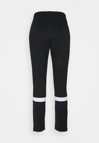 Schwarze Sporthose mit elastischem Bund, mit weißen Streifen am Saum und Reißverschlussakzenten am Ende. Glatte Textur.