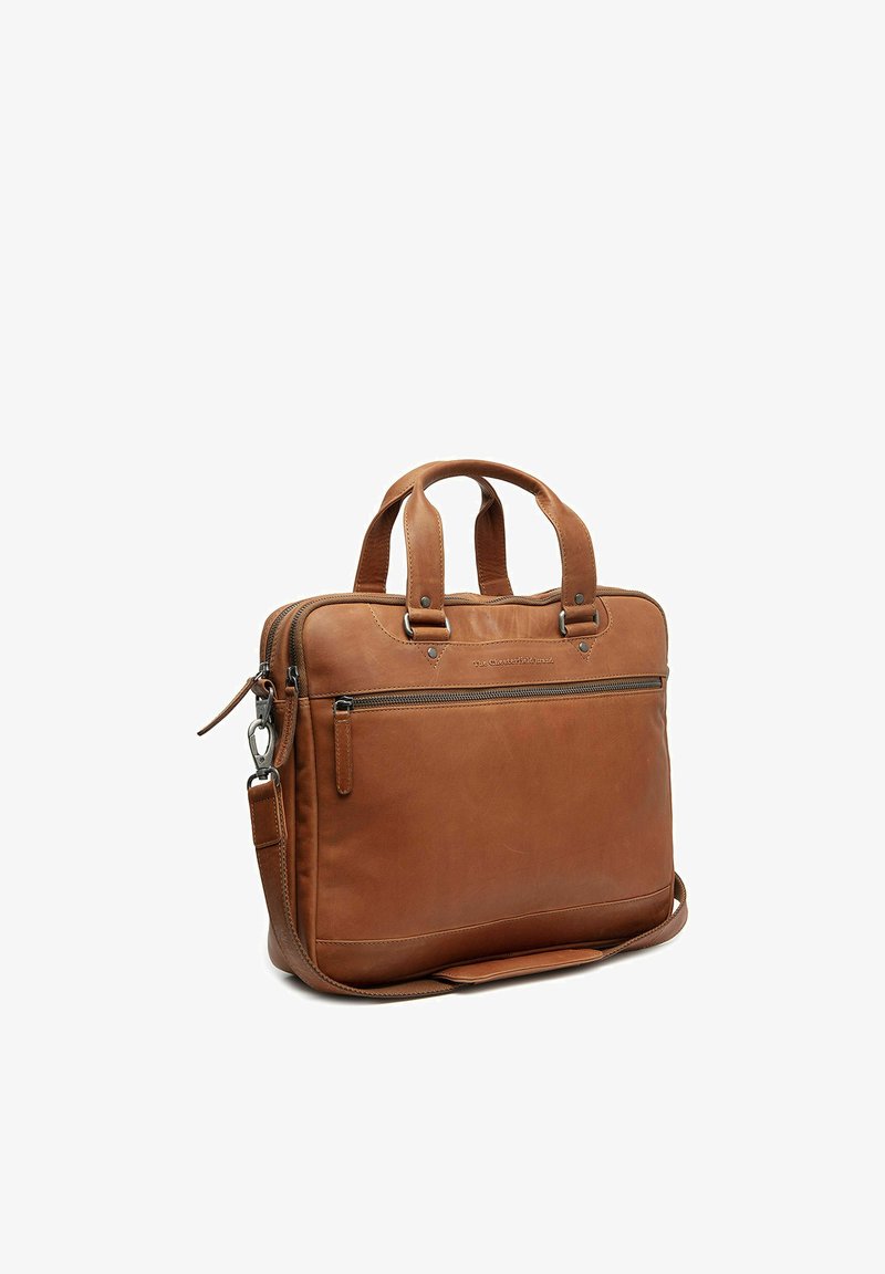 Mallette en cuir marron avec double poignées, poche avant zippée, bandoulière amovible et fermeture principale zippée, présentée en angle sur fond blanc.