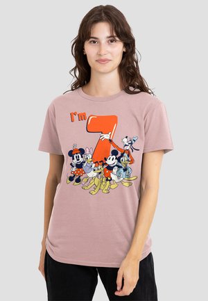 Pink cotton t-shirt featuring a graphic of cartoon characters, with orange text “I’m 7” printed prominently in front. Short sleeves, crew neck.