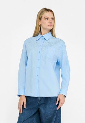 Lichtblauw knoopshirt met een kraag, lange mouwen en metallic accentdetails. Beschikt over een borstzak en een gladde, gestructureerde stof.