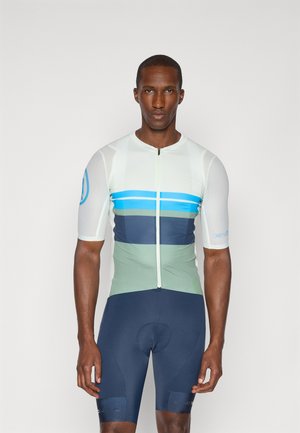 Maillot de cyclisme à manches courtes en menthe clair, avec des rayures horizontales bleues et vertes, doté d'une fermeture éclair à l'avant et porté avec un short ajusté bleu marine.