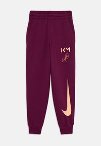 Bordo trenirke s elastičnim pojasom, bočnim džepovima, zlatnim logotipom "KM" i velikim narančastim Nike swoosh dizajnom na lijevoj nozi.