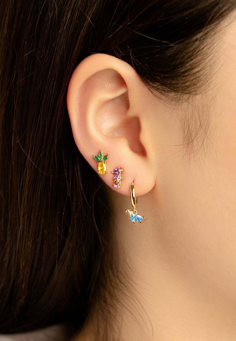Guldörhängen med en ananas, en gul ädelsten och flerfärgade stenar tillsammans med en blå dinosaurie charm på en hoop.