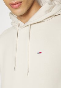 Felpa cremisi con cappuccio e cordini, caratterizzata da un piccolo logo ricamato in rosso, bianco e blu. Tessuto morbido con un design a vestibilità rilassata.