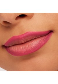 Rouge à lèvres rose mat sur des lèvres pleines avec une texture lisse. La lèvre supérieure a une teinte légèrement plus foncée, ce qui met en valeur la forme et la définition.