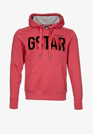 Sweat à capuche rouge avec poche avant, texte "G STAR" en noir et rouge foncé, cordons de serrage et doublure intérieure grise de la capuche.